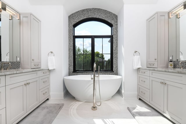 bathroom featuring backsplash, vanity, and a bathtub