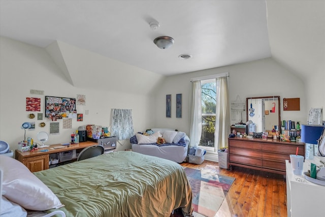 bedroom with vaulted ceiling and light wood-type flooring