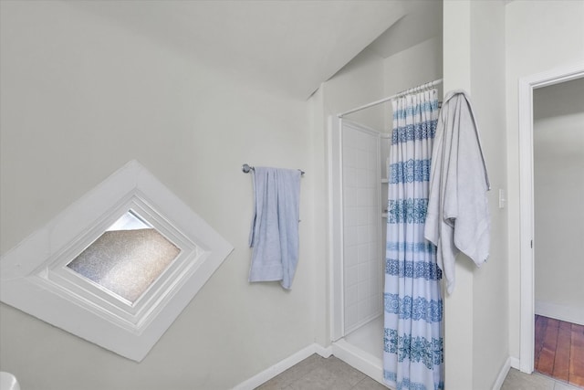 bathroom with lofted ceiling, tile patterned floors, and a shower with shower curtain