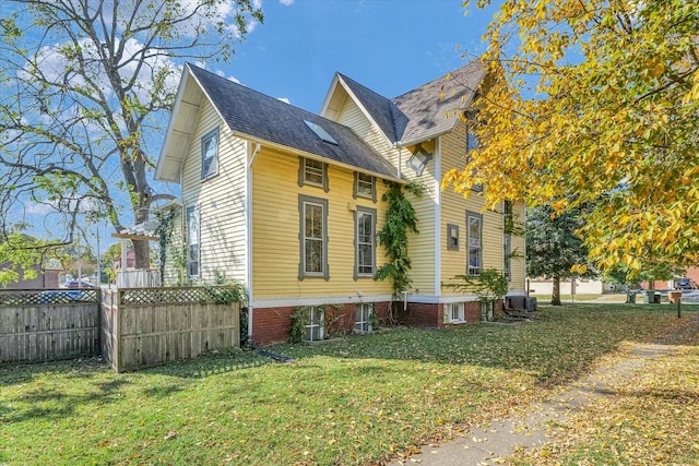 view of side of property with central AC unit and a lawn