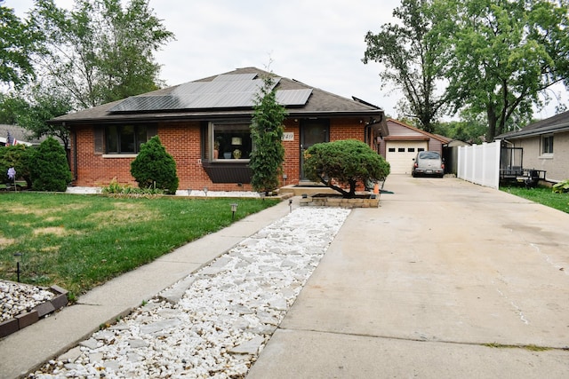 view of front of home with solar panels, a front yard, and a garage