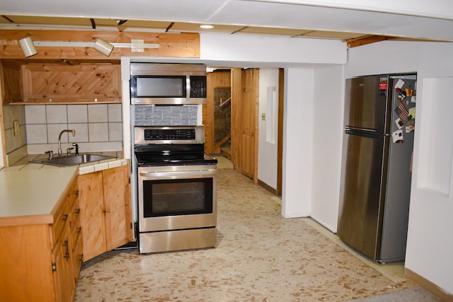 kitchen featuring backsplash, stainless steel appliances, and sink