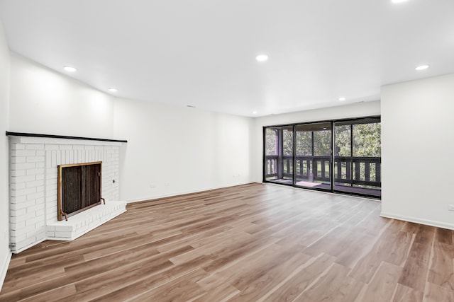 unfurnished living room with a fireplace and light hardwood / wood-style floors