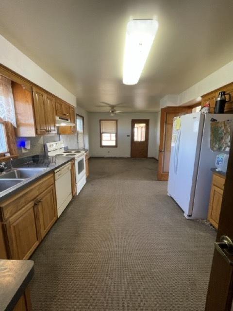 17580 1200 E St, Wyanet, IL 61379 - kitchen with white appliances, under cabinet range hood, brown cabinetry, and a sink