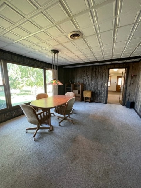 unfurnished dining area with wooden walls and carpet