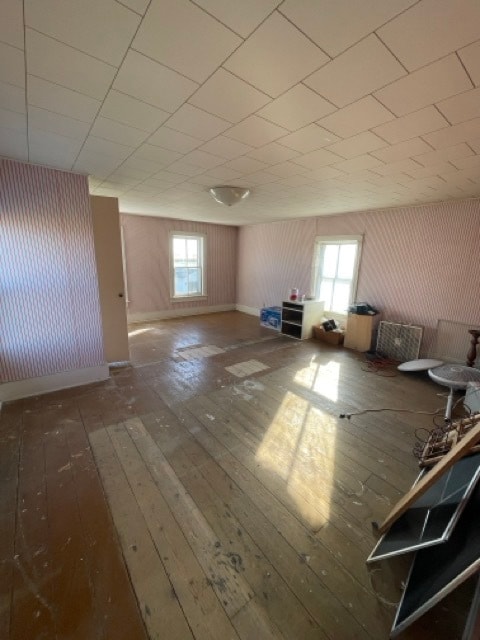 bonus room with a healthy amount of sunlight and dark hardwood / wood-style flooring