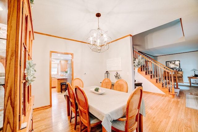 dining space with light wood finished floors, baseboards, a chandelier, stairs, and ornamental molding