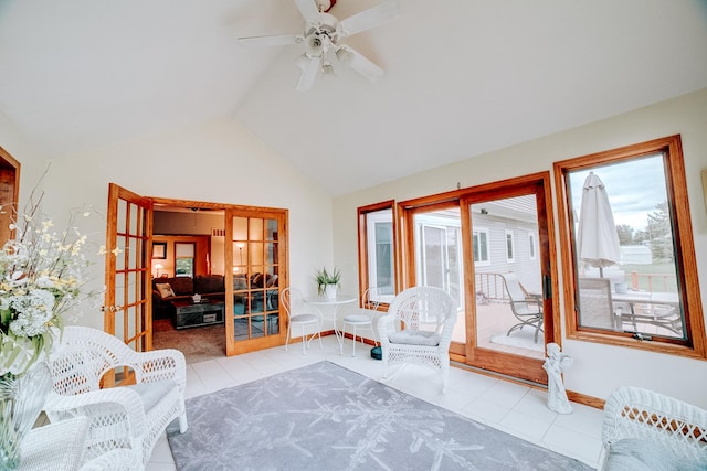 tiled living room with ceiling fan, french doors, baseboards, and lofted ceiling
