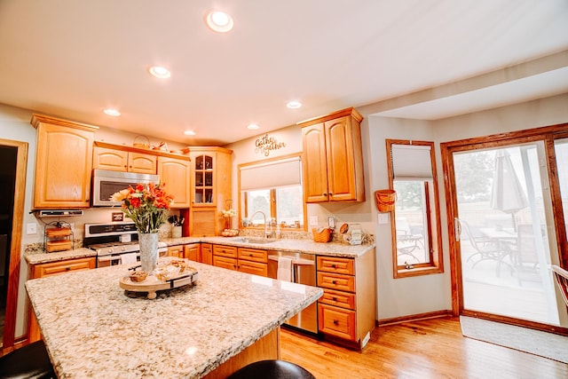 kitchen featuring a sink, recessed lighting, stainless steel appliances, light wood-style floors, and light stone countertops