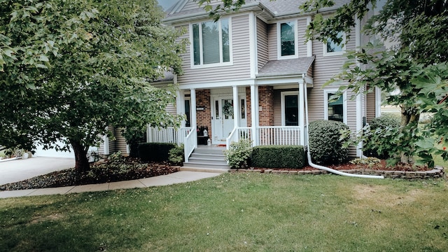 view of front of property with covered porch and a front lawn