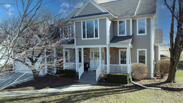 view of front of home with a porch and a shingled roof