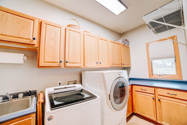 laundry area featuring sink, washer and dryer, cabinets, and light tile patterned floors