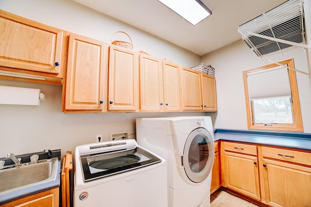 clothes washing area featuring washer and dryer, light tile patterned flooring, cabinet space, and a sink