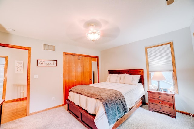 carpeted bedroom with a closet, visible vents, ceiling fan, and baseboards