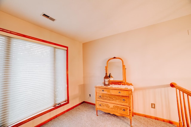 living area featuring baseboards, visible vents, carpet floors, and a healthy amount of sunlight