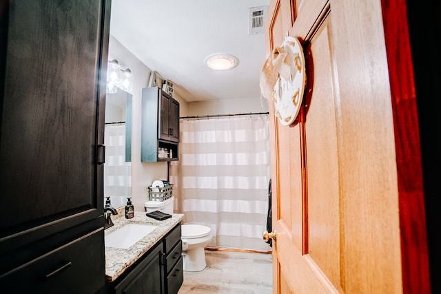 bathroom with vanity, toilet, hardwood / wood-style flooring, and curtained shower