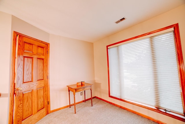carpeted spare room with visible vents and baseboards