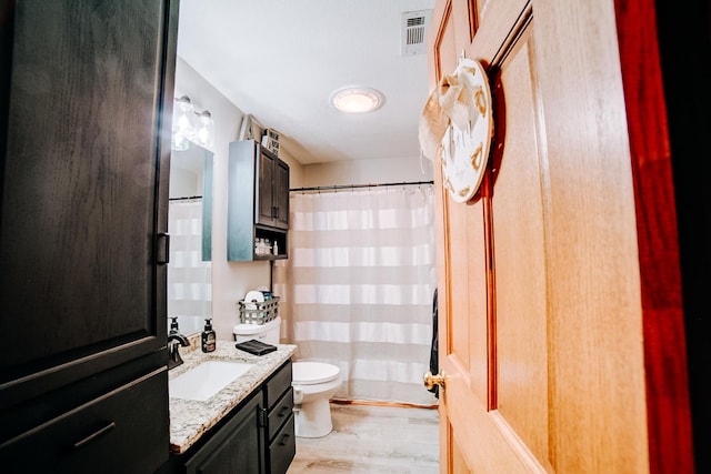 full bath featuring vanity, wood finished floors, visible vents, curtained shower, and toilet