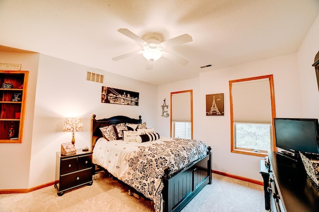 bedroom with light carpet, visible vents, a ceiling fan, and baseboards