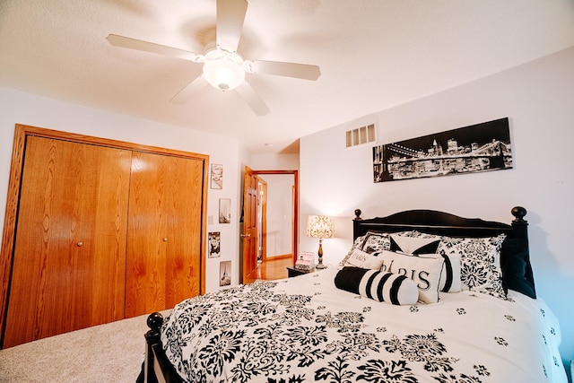 bedroom with a ceiling fan, visible vents, a closet, and carpet floors