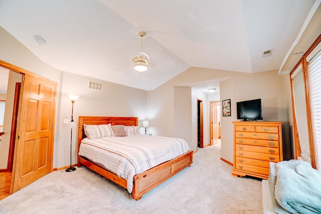 carpeted bedroom with ceiling fan and vaulted ceiling