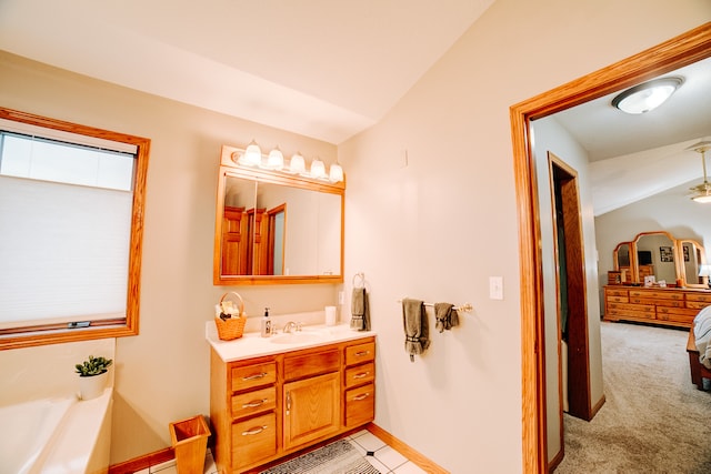 bathroom with vanity, ceiling fan, a bath, and vaulted ceiling