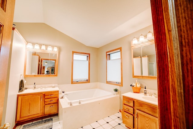 bathroom with a sink, two vanities, a garden tub, and vaulted ceiling