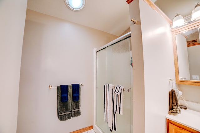 bathroom featuring vanity, lofted ceiling, and a shower with shower door