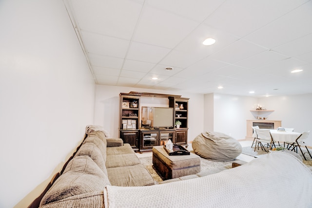 living room with a drop ceiling and a fireplace