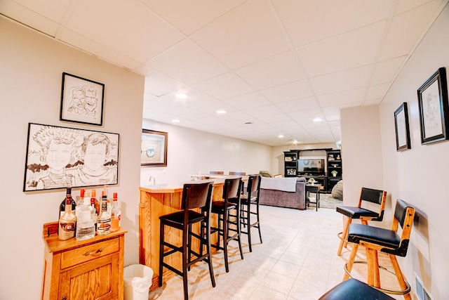 dining space featuring recessed lighting, wet bar, and a paneled ceiling