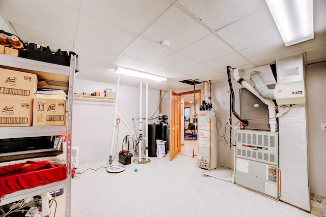 basement featuring water heater, a drop ceiling, carpet floors, and heating unit