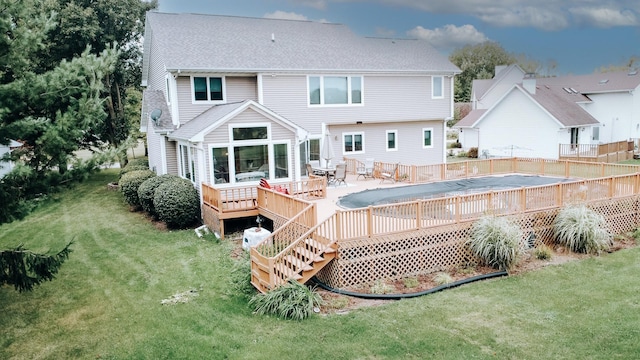 rear view of house featuring a fenced in pool, fence, a wooden deck, a yard, and a shingled roof