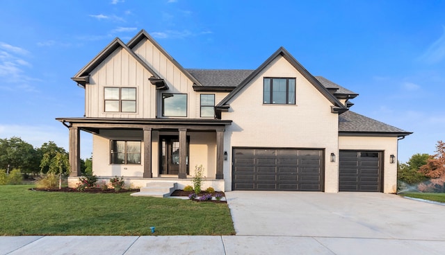 view of front of home featuring a garage, a front yard, and covered porch