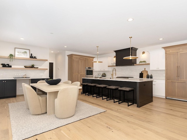 dining area with sink and light wood-type flooring