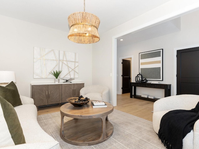 living room featuring light wood-type flooring and an inviting chandelier