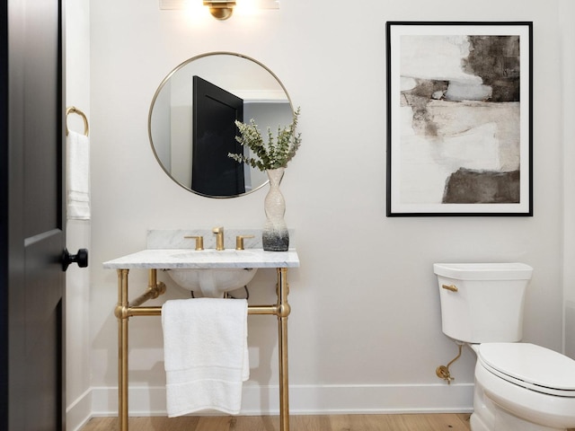 bathroom with hardwood / wood-style floors and toilet