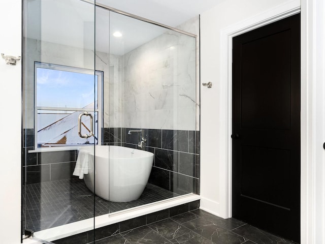 bathroom with tile walls and separate shower and tub