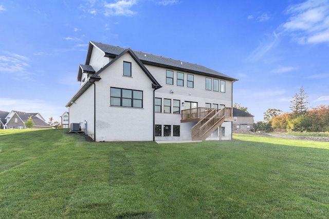 rear view of house with a wooden deck, a lawn, and central air condition unit