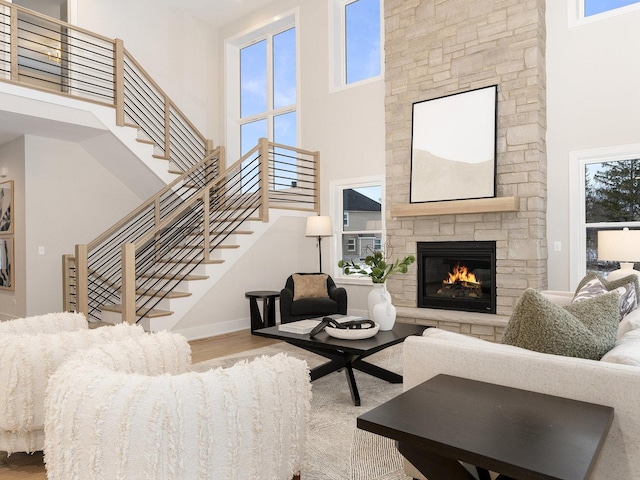 1519 77th St, Naperville, IL 60565 - living room with a towering ceiling, wood finished floors, stairway, a stone fireplace, and baseboards