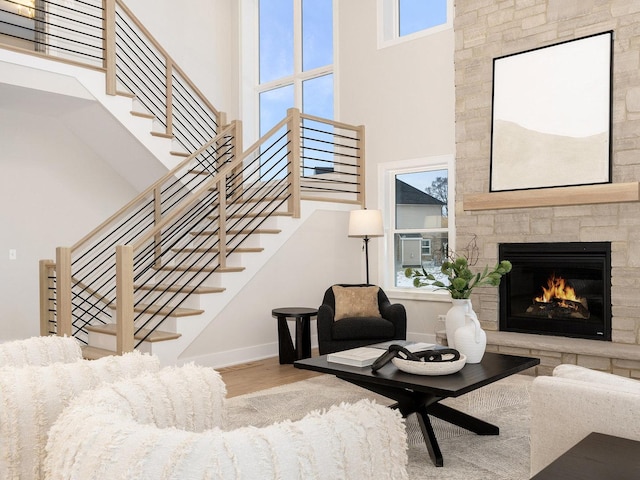 1519 77th St, Naperville, IL 60565 - living room featuring a towering ceiling, wood finished floors, stairway, a fireplace, and baseboards