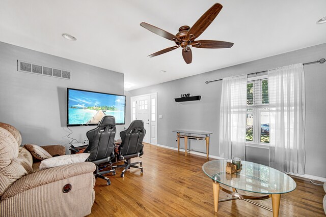 home office with light hardwood / wood-style floors and ceiling fan