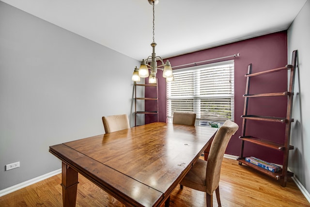 dining room with light hardwood / wood-style flooring and a chandelier