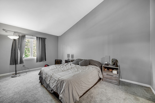 carpeted bedroom with lofted ceiling