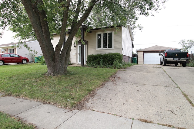 view of front facade featuring an outbuilding, a garage, and a front yard