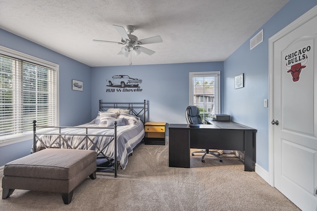 carpeted bedroom with a textured ceiling and ceiling fan