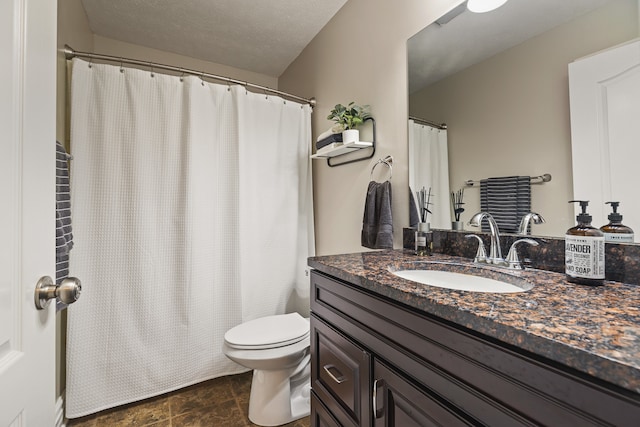 bathroom featuring vanity, a textured ceiling, and toilet