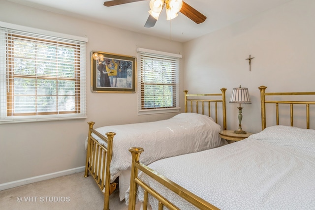 carpeted bedroom with ceiling fan and multiple windows