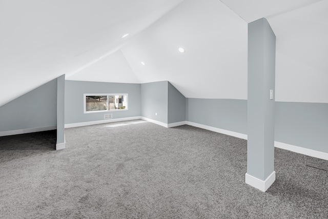 additional living space featuring carpet flooring and vaulted ceiling