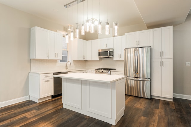 kitchen with a center island, dark wood-type flooring, decorative light fixtures, white cabinetry, and stainless steel appliances