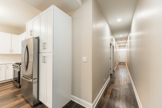 kitchen with dark hardwood / wood-style floors, decorative backsplash, white cabinetry, and stainless steel appliances